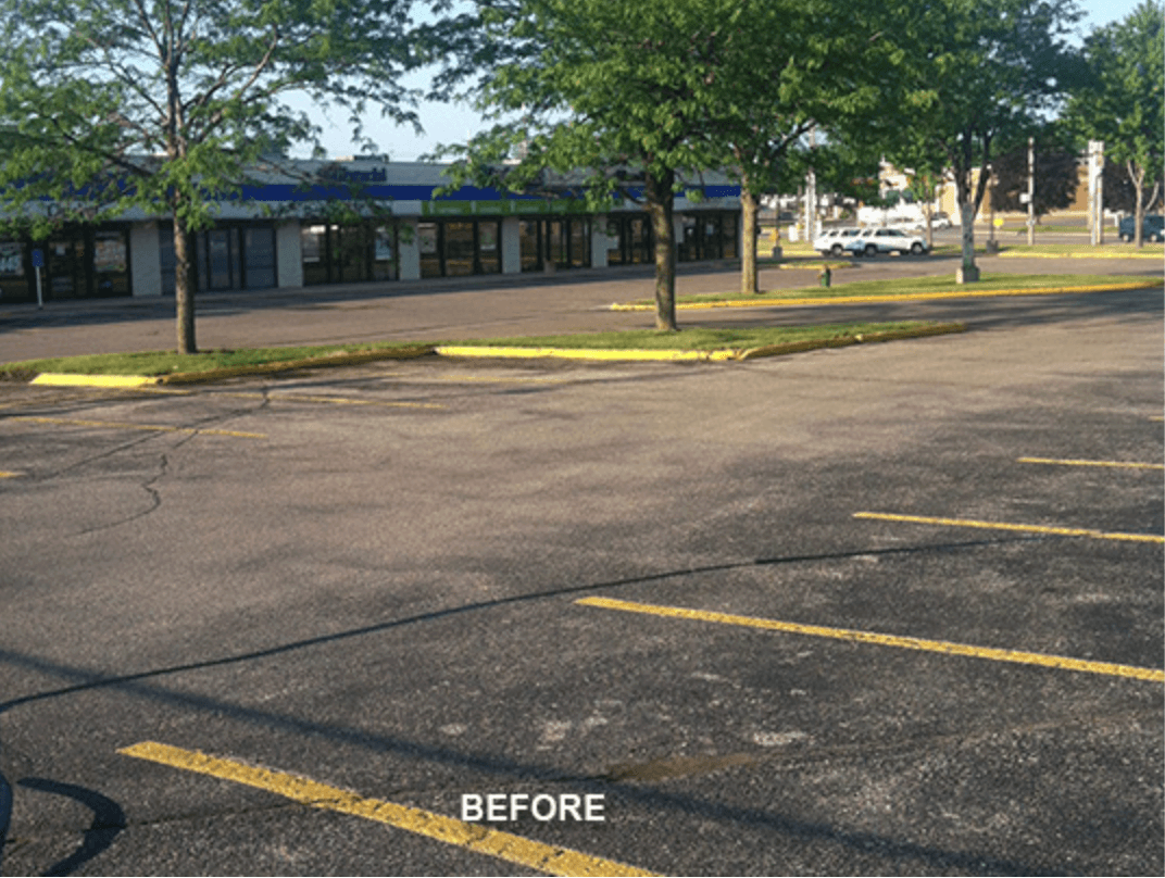 Before photo showing cracked asphalt parking lot in Katy retail center